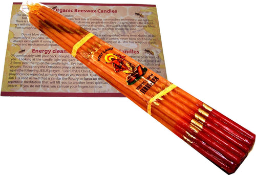 Gold-leaf decorated beeswax candle bundle lying on the printed instruction leaflet #color_Brown