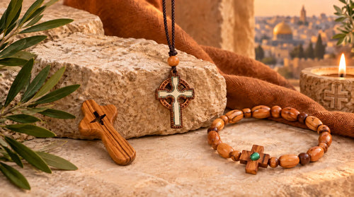 Olive wood cross, Jerusalem cross necklace, and rosary bracelet displayed as Catholic gifts from the Holy Land.