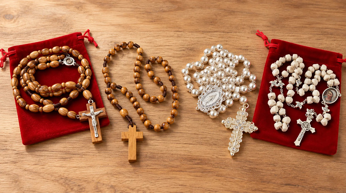 Two olive wood rosaries and two crystal rosaries displayed side by side on a natural wooden background.