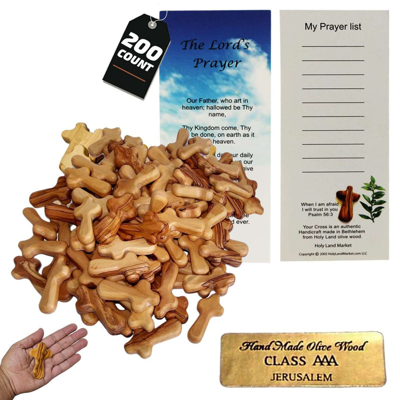 Large pile of olive wood pocket crosses with prayer cards and seal