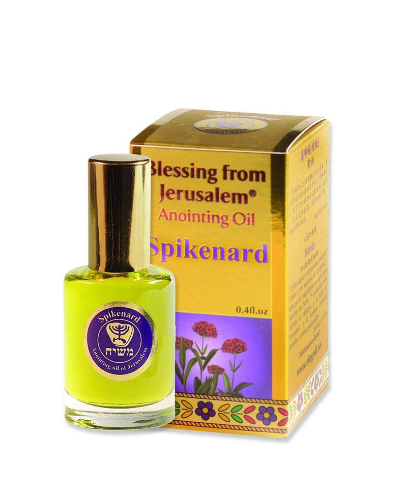 Gold box with purple panel of pink spikenard flowers, beside oil bottle